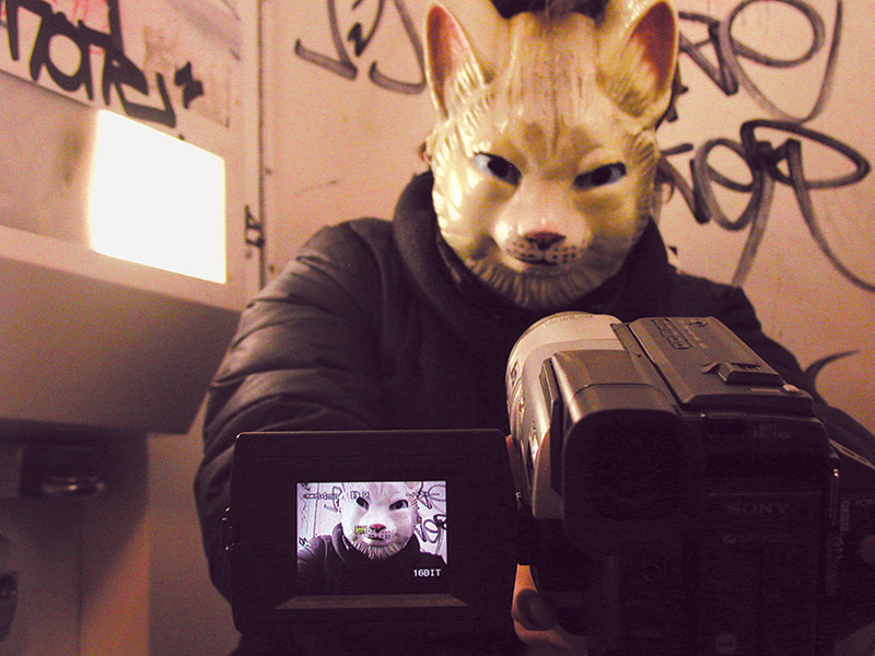 Super Night Shot image of man in cat mask filming