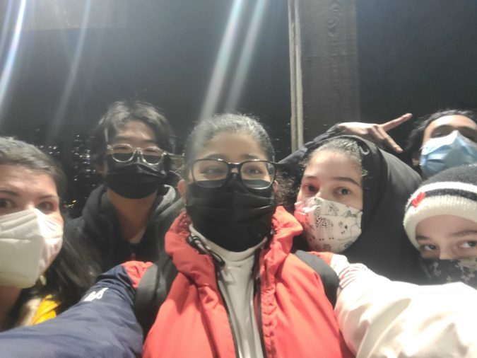 A group selfie with several young people wearing masks.