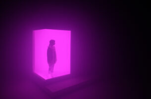 A figure wearing a warm coat and a long braid stands in silhouette within a cube of hazy glowing purple light. The atmosphere is cold, as though the cube might be a block of ice.