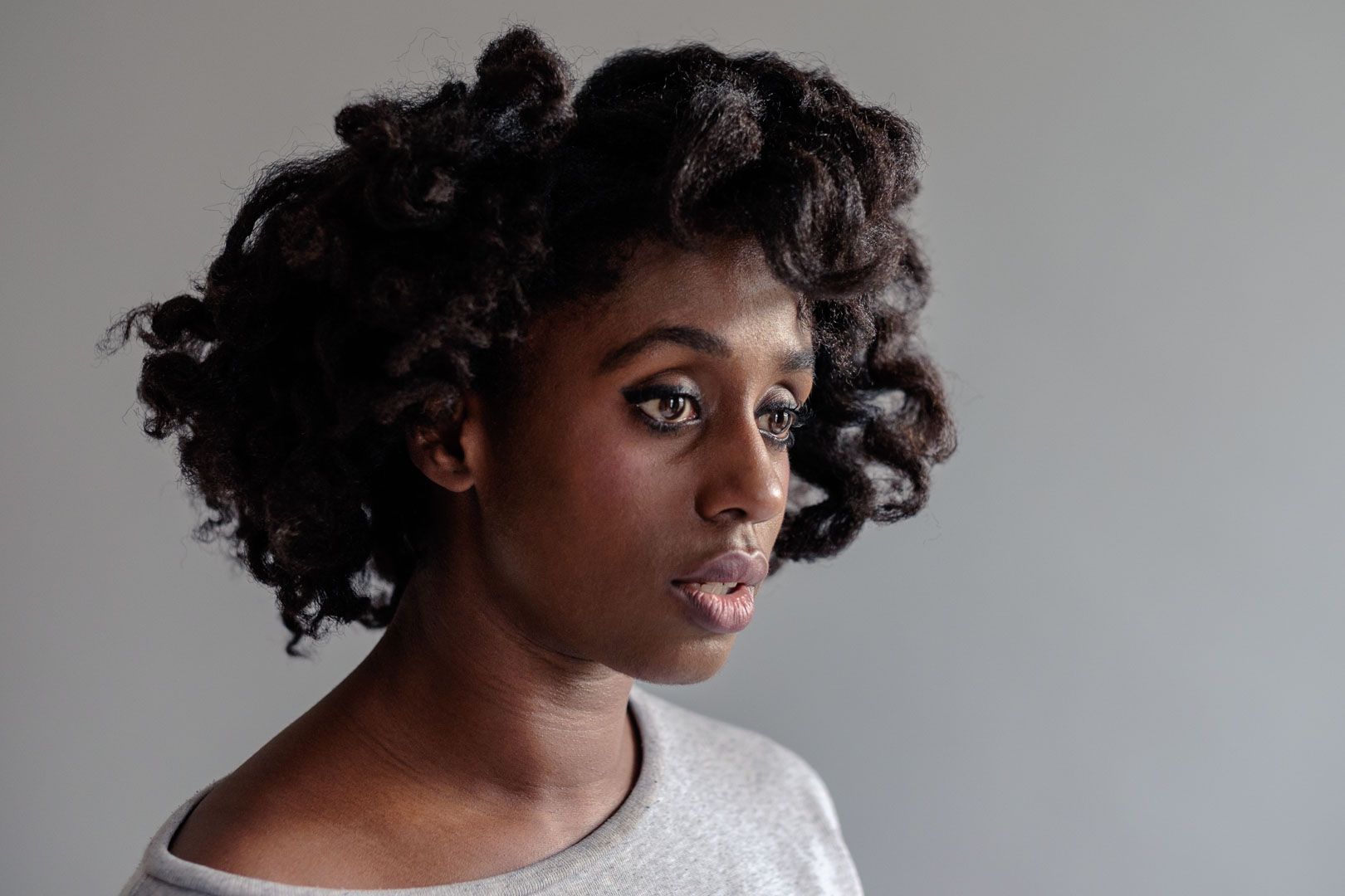 Portrait of Nwando Ebizie in profile. Nwando has black curly hair and is wearing a gray shirt.